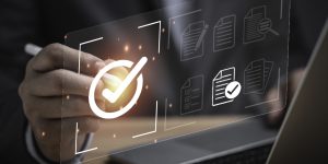 Businessman using laptop computer with correct sign mark and document icon for ISO or International Standard Organisation which related quality control and continuous improvement concept.