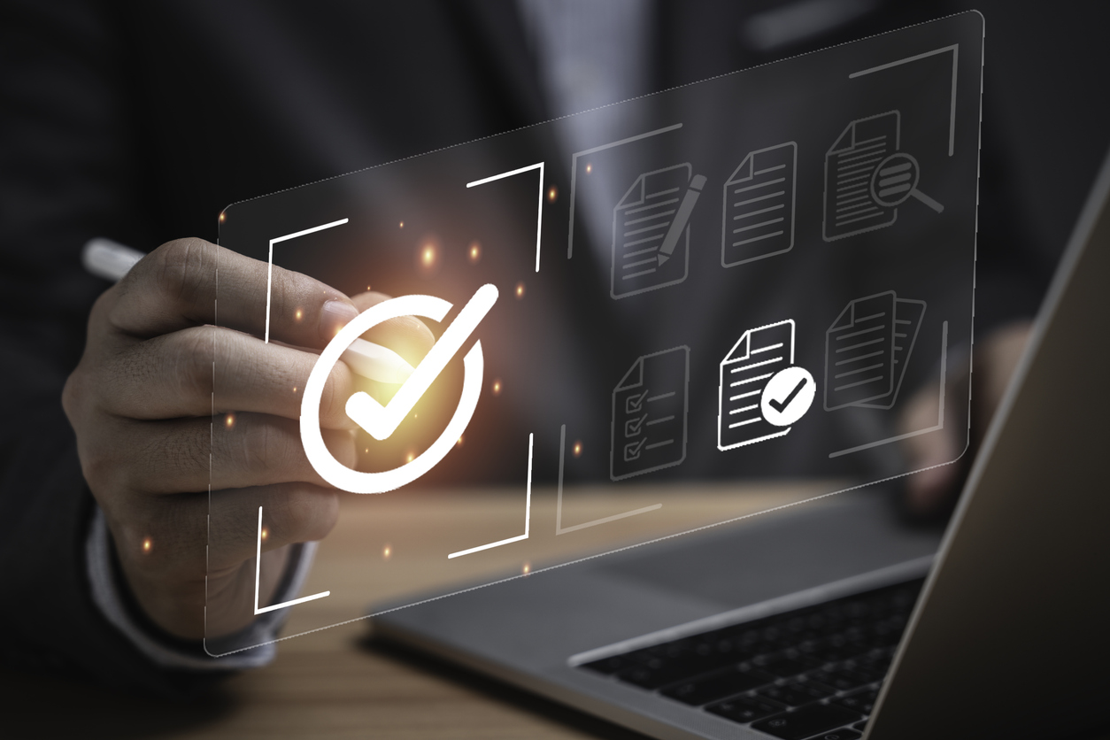 Businessman using laptop computer with correct sign mark and document icon for ISO or International Standard Organisation which related quality control and continuous improvement concept.