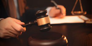 Man is holding a gavel and working in the office. Lawyer at work