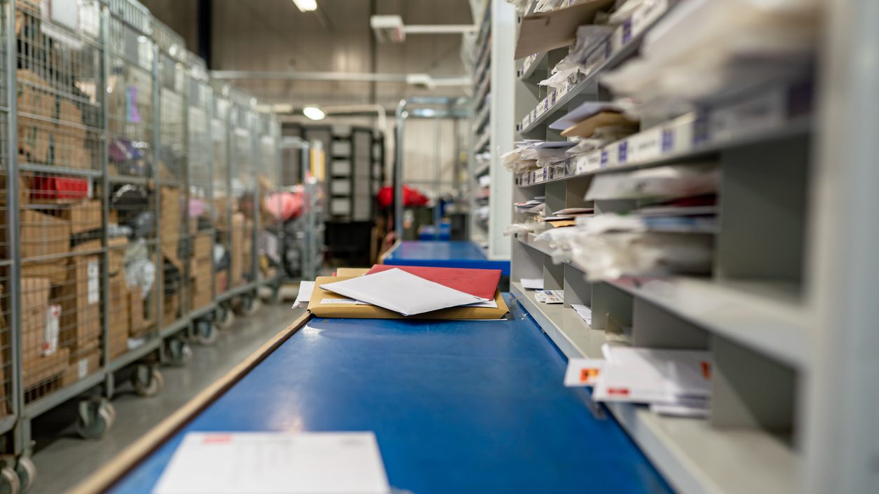 Letters on a sorting frame, table and shelves in a mail delivery sorting centre. Postal service, post office inside