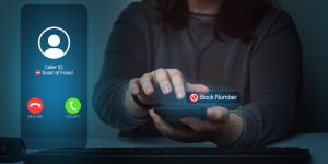 Woman blocking scam call on smartphone