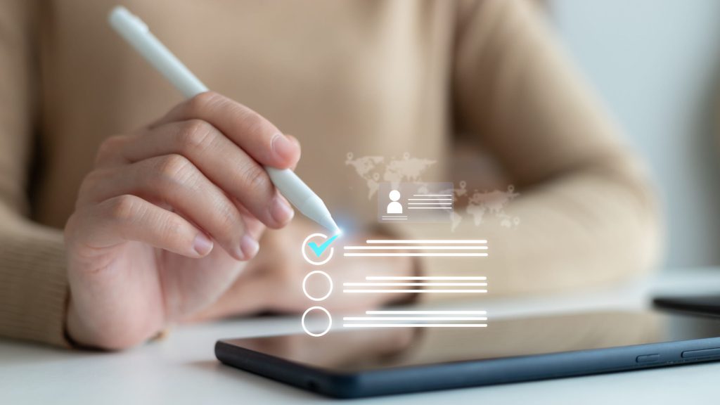 Hand using a stylus on a tablet with a virtual checklist and profile form