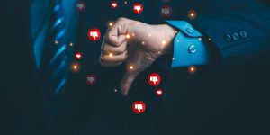 Businessman giving a thumbs down with negative feedback icons