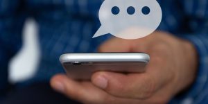 Hand of man typing text on mobile smartphone