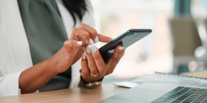 Phone, office and business woman networking on social media, the internet or a mobile app